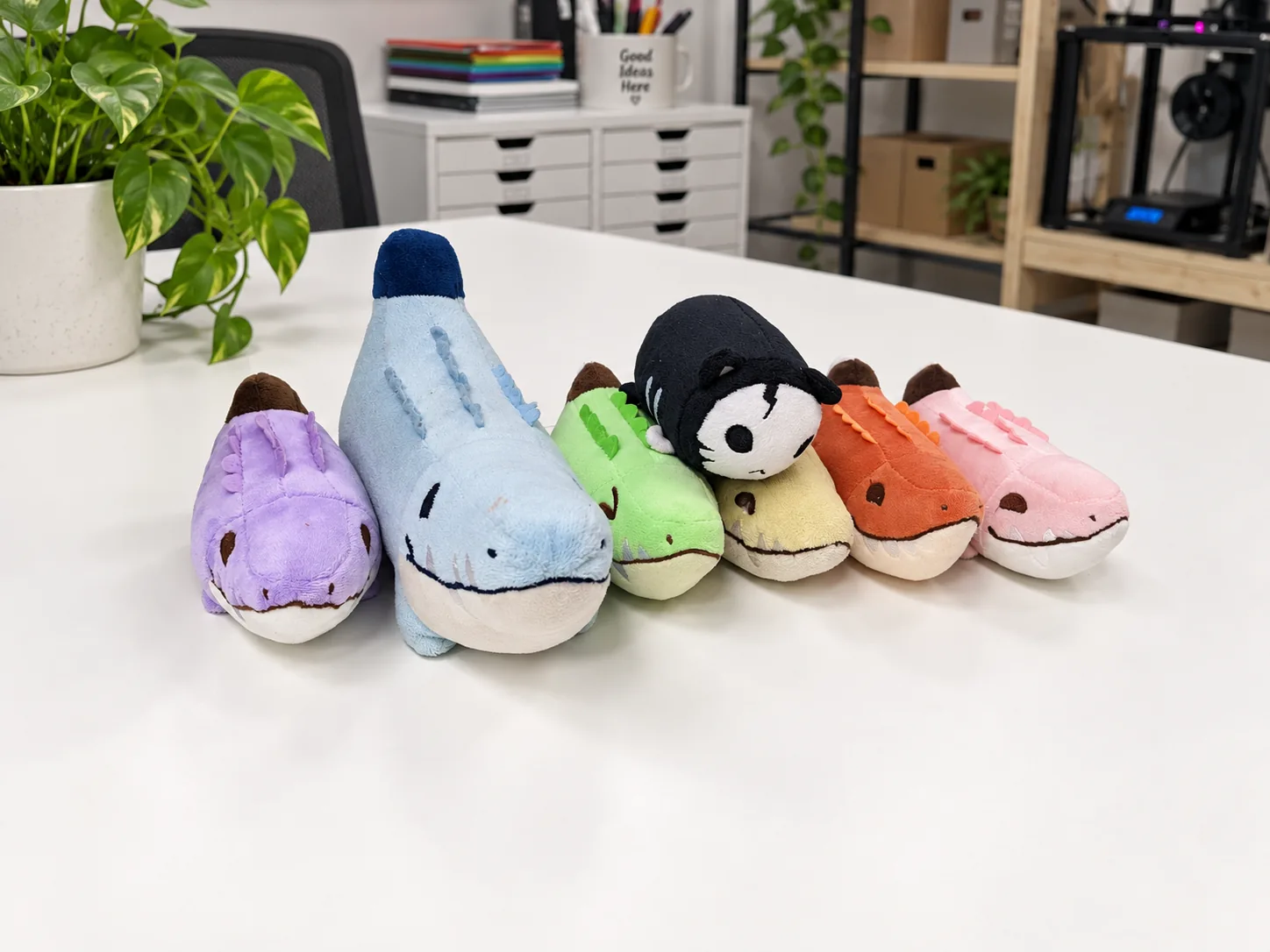 Colorful plush sharks on a studio worktable