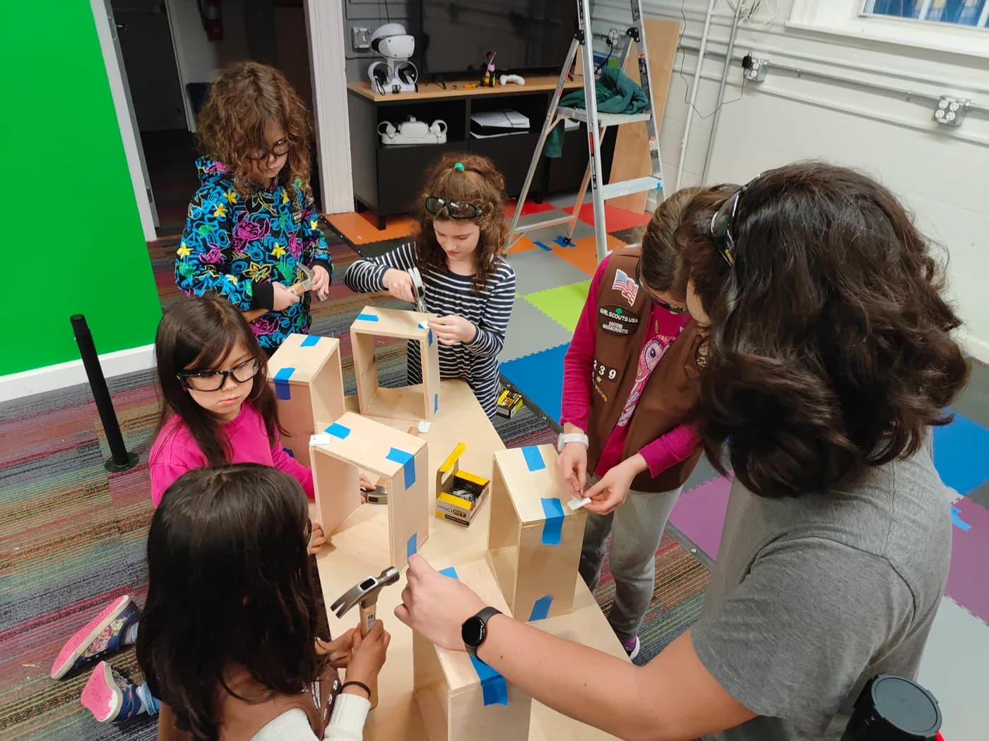 Scouts assembling wooden boxes with adult guidance