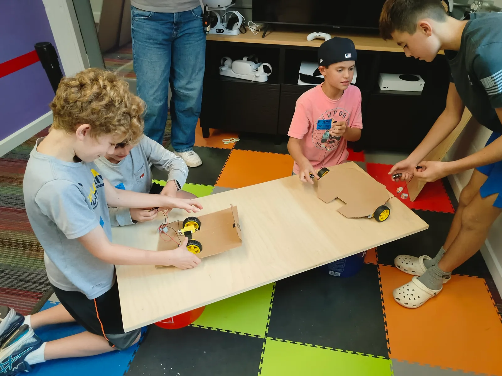 Young learners testing cardboard robots together